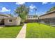 A well-maintained backyard featuring a grassy lawn, a concrete path, and privacy fencing at 1208 S Elizabeth St, Denver, CO 80210