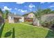 Lush backyard with healthy grass, a detached garage, and a brick wall in the corner at 1208 S Elizabeth St, Denver, CO 80210