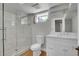 Modern bathroom with a frameless glass shower, white vanity, and light wood-look flooring at 1208 S Elizabeth St, Denver, CO 80210
