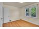 Cozy bedroom with hardwood floors, two windows, and a classic white door at 1208 S Elizabeth St, Denver, CO 80210