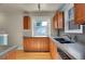 Well-lit kitchen featuring wood cabinets, stone countertops, and updated appliances at 1208 S Elizabeth St, Denver, CO 80210