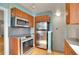 Kitchen with stainless steel appliances, wood cabinets, and modern lighting at 1208 S Elizabeth St, Denver, CO 80210