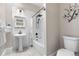 The remodeled bathroom features classic white subway tile, pedestal sink and updated fixtures and lighting at 328 E Dakota Ave, Denver, CO 80209