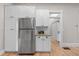 A closer view of the kitchen, featuring white cabinets, stainless steel refrigerator and granite countertops at 328 E Dakota Ave, Denver, CO 80209