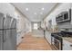 A bright, efficient kitchen offering ample white cabinetry, modern appliances, granite countertops, and hardwood floors at 328 E Dakota Ave, Denver, CO 80209