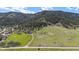 Expansive property featuring green fields, a dirt road, a scattering of buildings, and mountain views at 15947 S Perry Park Rd, Palmer Lake, CO 80133