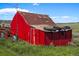Picture of a red barn with a rusting metal roof, sitting among tall grass at 15947 S Perry Park Rd, Palmer Lake, CO 80133