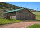 Rustic barn with green metal roof, adding charm and functionality to the property at 15947 S Perry Park Rd, Palmer Lake, CO 80133