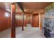 Spacious finished basement with stone fireplace, wood paneling, and exposed beams, offering a cozy and inviting space at 15947 S Perry Park Rd, Palmer Lake, CO 80133