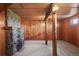 Finished basement with knotty pine paneling, a stone fireplace, and rustic wood supports, offering a warm retreat at 15947 S Perry Park Rd, Palmer Lake, CO 80133