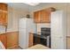 Bright kitchen featuring appliances, tile counters, and wood cabinets, complete with vintage floral wallpaper at 15947 S Perry Park Rd, Palmer Lake, CO 80133
