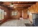 Cozy living room featuring wood-paneled walls, stone fireplace, and natural light at 15947 S Perry Park Rd, Palmer Lake, CO 80133
