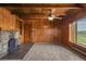 Charming living room with a stone fireplace, wood paneled walls, and bright windows at 15947 S Perry Park Rd, Palmer Lake, CO 80133