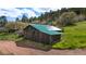 Rustic outbuilding with a green metal roof and wood siding at 15947 S Perry Park Rd, Palmer Lake, CO 80133
