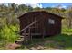 Small wood cabin in a forest setting, featuring a rustic design at 15947 S Perry Park Rd, Palmer Lake, CO 80133