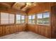 Bright sunroom with multiple windows, wood paneling, and scenic views at 15947 S Perry Park Rd, Palmer Lake, CO 80133