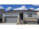 Charming single-Gathering home showcasing a gray exterior, stone accents, and an attached two-car garage at 17085 W 92Nd Loop, Arvada, CO 80007
