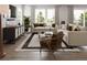 Living room featuring neutral sofas, a modern rug, decorative artwork, and sun-filled windows at 17085 W 92Nd Loop, Arvada, CO 80007