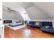 Open attic room with a plush bed, cozy blue sofa, and modern ceiling fan at 2358 N Ogden St # B, Denver, CO 80205