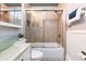 Well-lit bathroom featuring a glass bowl sink, bathtub with sliding glass doors, and tiled walls at 2358 N Ogden St # B, Denver, CO 80205