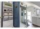 Updated bathroom features modern vanity, glass shower, and ample storage shelving at 2358 N Ogden St # B, Denver, CO 80205