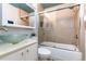 Well-lit bathroom featuring a glass bowl sink, bathtub with sliding glass doors, and tiled walls at 2358 N Ogden St # B, Denver, CO 80205