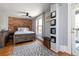 Comfortable bedroom featuring a large brick wall and wood floors at 2358 N Ogden St # B, Denver, CO 80205