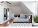 Cozy attic bedroom features a plush bed, modern fireplace, and hardwood floors at 2358 N Ogden St # B, Denver, CO 80205