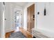 Hallway features hardwood floors, white trim, and a view of the front entrance at 2358 N Ogden St # B, Denver, CO 80205