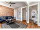 Bright living room with exposed brick, hardwood floors, and connecting hallways at 2358 N Ogden St # B, Denver, CO 80205