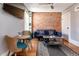 Living room features an exposed brick wall, hardwood floors, and contemporary furnishings at 2358 N Ogden St # B, Denver, CO 80205