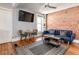 Living room with exposed brick, a blue sofa, and modern decor at 2358 N Ogden St # B, Denver, CO 80205
