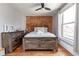 Cozy bedroom with exposed brick wall, wood floors, and large window at 2358 N Ogden St # B, Denver, CO 80205