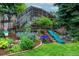 Lush backyard landscaping with mature plants and a fun slide for outdoor play at 14428 W Ellsworth Pl, Golden, CO 80401