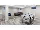 Finished basement featuring a recreation area with gray laminate flooring, a gray couch, and an air hockey table at 14428 W Ellsworth Pl, Golden, CO 80401