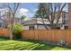 Backyard with wood fence, green grass, and mature trees at 6358 S Jackson St, Centennial, CO 80121