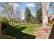 Large backyard with green grass and mature trees and shrubbery at 6358 S Jackson St, Centennial, CO 80121