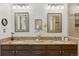 Bathroom featuring double vanity with granite counters, decorative mirrors, and updated lighting at 6358 S Jackson St, Centennial, CO 80121