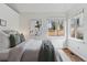 Bright bedroom featuring a large window, white walls, and a cozy bed with decorative pillows at 6358 S Jackson St, Centennial, CO 80121