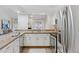 Open kitchen with stainless appliances, white cabinets, and granite counters overlooking a living area at 6358 S Jackson St, Centennial, CO 80121