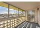 Enclosed balcony features patterned brick, a view of the neighborhood, and carpeted floor at 720 S Clinton St # 2D, Denver, CO 80247