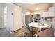 Cozy dining area featuring a modern round table, stylish chairs, and a view of the updated kitchen at 720 S Clinton St # 2D, Denver, CO 80247