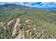 Panoramic aerial view showing a home secluded among trees on a mountain slope at 30671 Bearcat Trl, Conifer, CO 80433