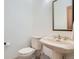 A cozy half bath featuring a classic pedestal sink, gold fixtures and neutral tones at 30671 Bearcat Trl, Conifer, CO 80433