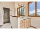 Bathroom featuring a vanity with marble countertops, custom cabinets, a shower, and lots of natural light at 30671 Bearcat Trl, Conifer, CO 80433