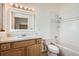 Bright bathroom with a tiled shower-over-tub, wood vanity and white tile and countertops at 30671 Bearcat Trl, Conifer, CO 80433