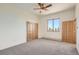 Spacious bedroom with neutral carpet, double closets, a ceiling fan, and bright window at 30671 Bearcat Trl, Conifer, CO 80433