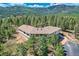 Stunning hillside home surrounded by evergreens featuring a wrap-around design and mountain views at 30671 Bearcat Trl, Conifer, CO 80433