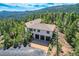 Exterior of home with three-car garage nestled among trees with mountain views at 30671 Bearcat Trl, Conifer, CO 80433