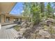 Stunning home with a wooden deck and lush natural landscaping featuring trees and boulders at 30671 Bearcat Trl, Conifer, CO 80433